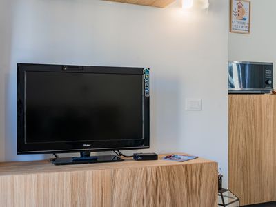 La televisione a schermo piatto sul mobile in legno.