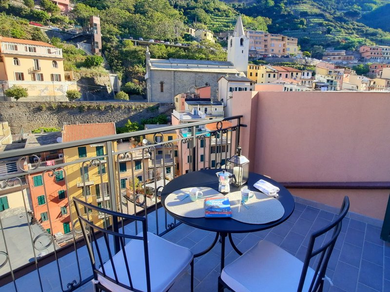 Terrazza privata con tavolo e vista sul borgo e sulla chiesa di Riomaggiore nelle Cinque Terre