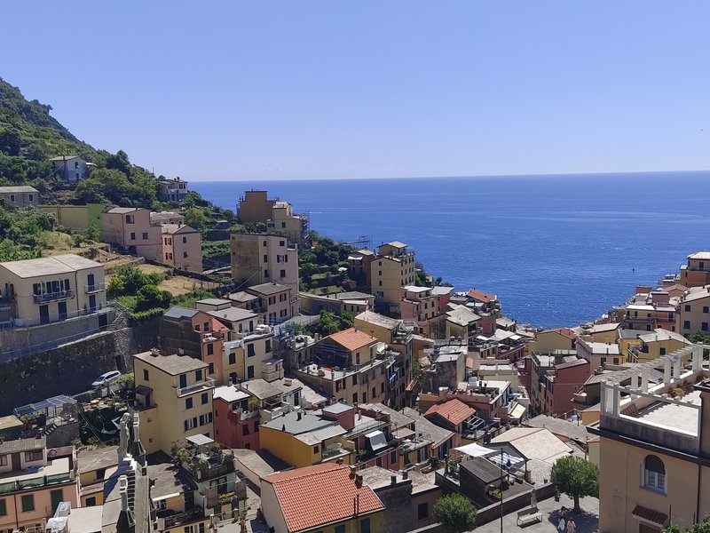 Vista da sopra la piazza principale verso il mare, con le case colorate di Riomaggiore